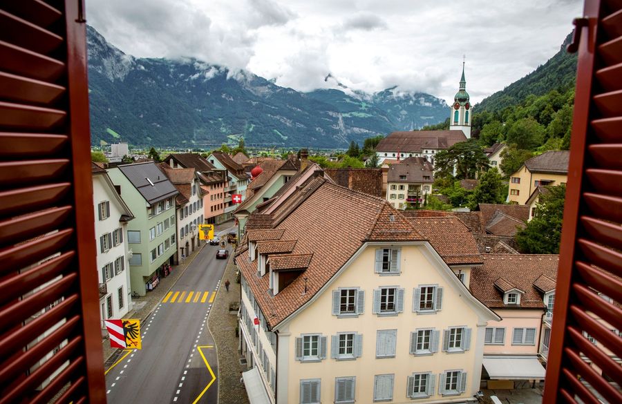 Open window shutters, tiled roofs, and prominent church spire of Altdorf, Switzerland