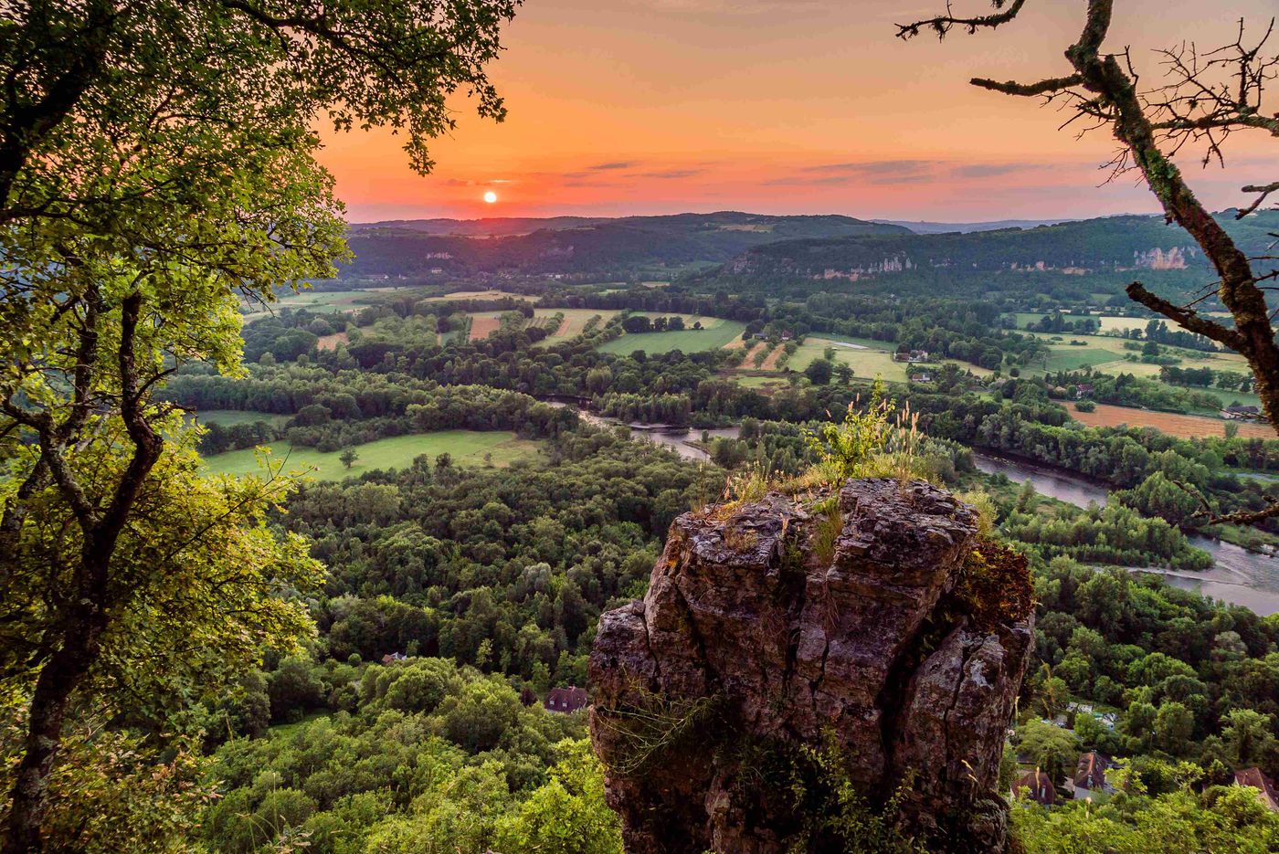 Sunset over fields and river and cliff Dordogne