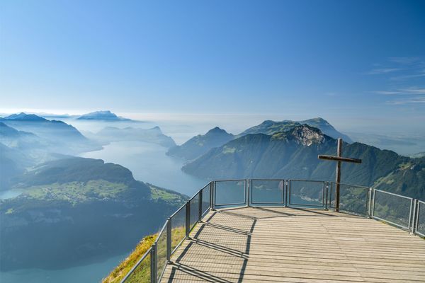 Wooden viewing platform and summit cross on top of the Fronalpstock peak near Stoos village