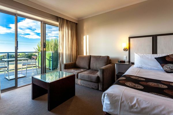 beachfront motel room with couch and floor length windows